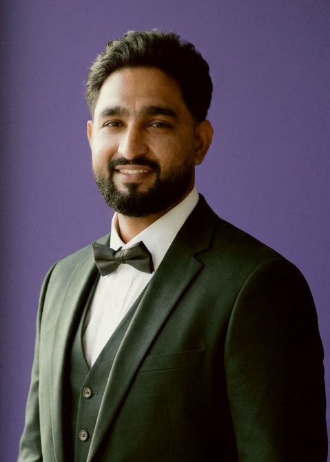 Nic, wedding filmmaker, in a dark green three piece suit
